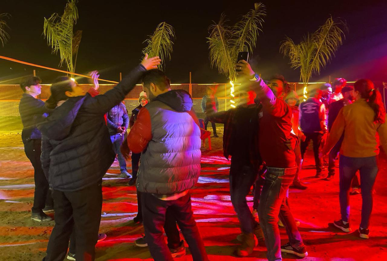 Guests enjoying bonfire and music at riverside resort in Rishikesh