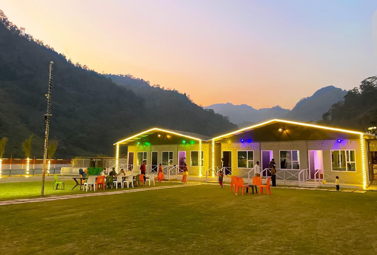 Riverside cottages in Rishikesh glowing with evening lights